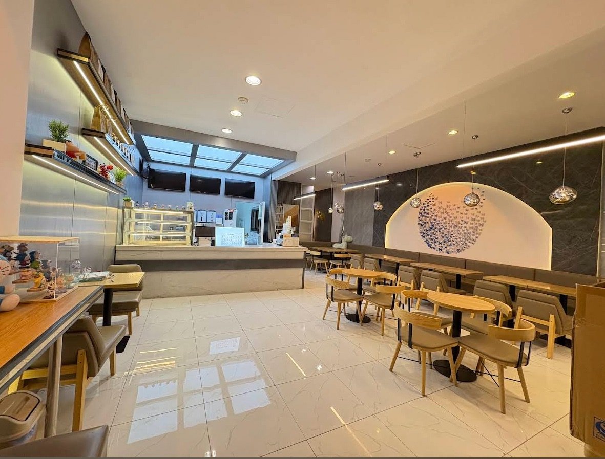 鹊茶明亮宽敞的店内空间，大面积落地窗采光，木质吧台与拱形墙面装饰，开放式座位区静候城市新访客
